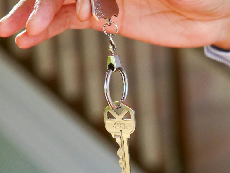 Close-up of a hand holding a key, symbolizing new homeownership or rental.