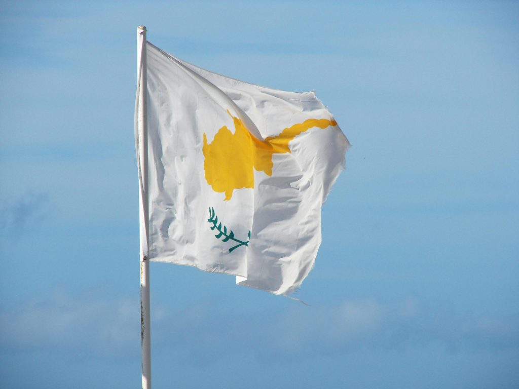 The national flag of Cyprus waving in the breeze against a clear blue sky.